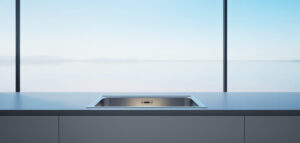 Minimalist kök med diskbänk och bänkskiva i ljusa färger.