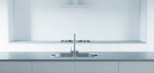 Minimalistiskt kök med diskho i rostfritt stål, rent och modernt.