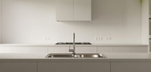 Modernt minimalistiskt kök med diskho och kran i rostfritt stål.