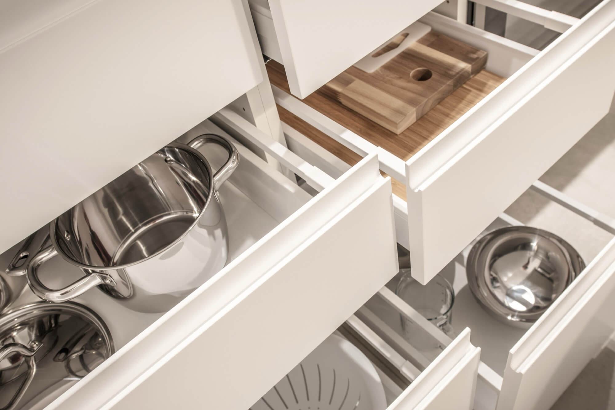 Välorganiserade kökslådor fyllda med kastruller och redskap, resultatet av en smart köksrenovering.