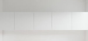 Fotorealistisk bild av en ensam, vit kökslucka på en vit vägg. Minimalistisk design.