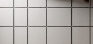 Närbild av vitt kakel med ljusgrå fog i modernt kök.